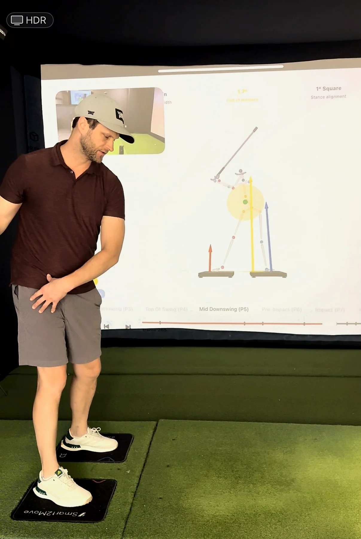 Dr. Jeremy Wampler standing on force plates while explaining golf swing mechanics.